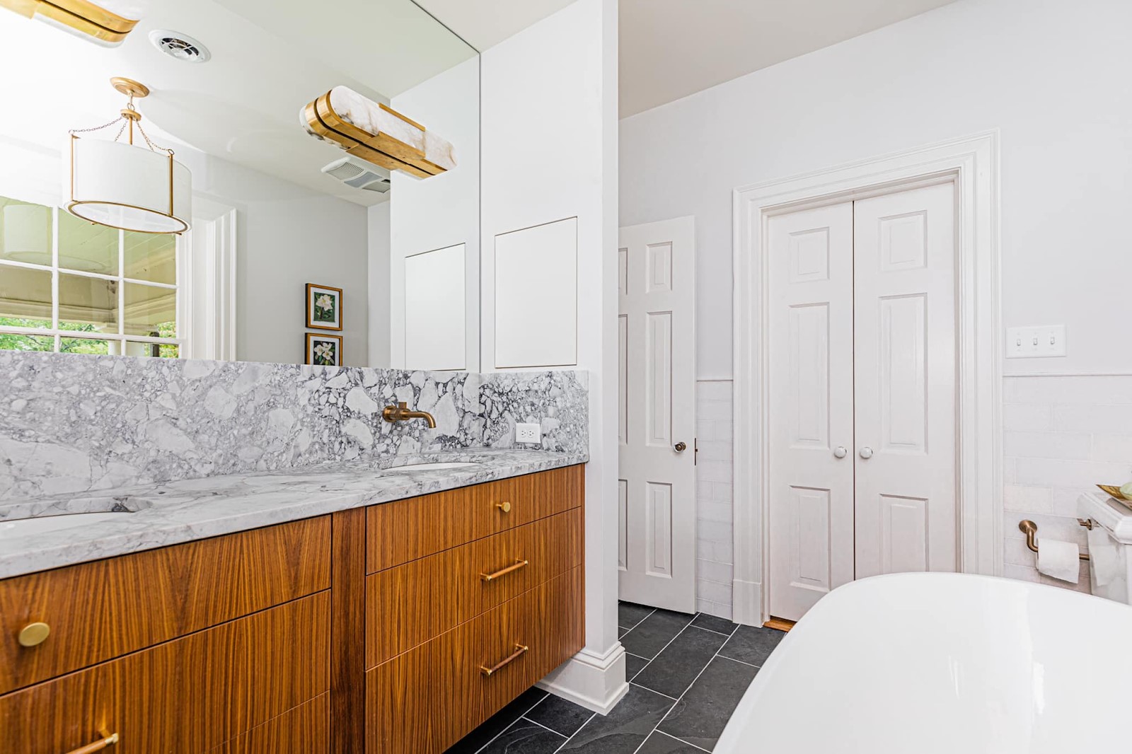 Beautiful bath remodel by BK Martin in Richmond, Virginia showing natural lighting reflecting off a mirror.