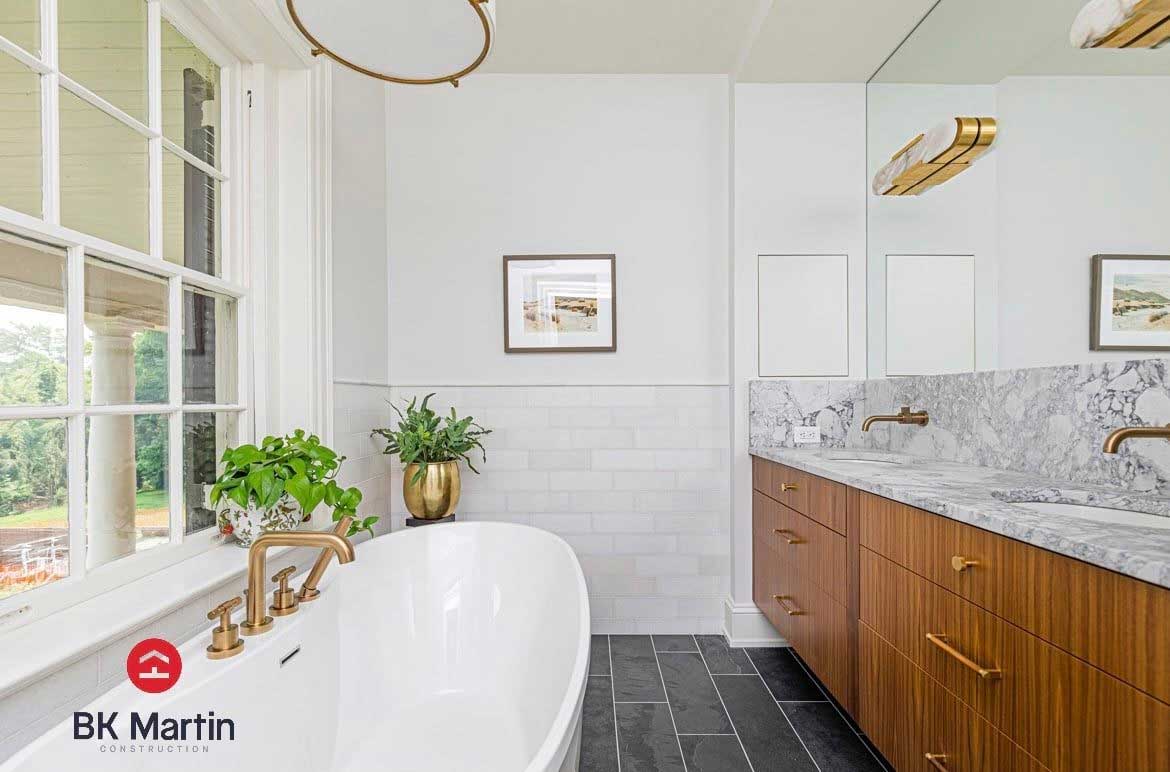 Beautiful bathroom with natural lighting by the tub across from a double vanity.