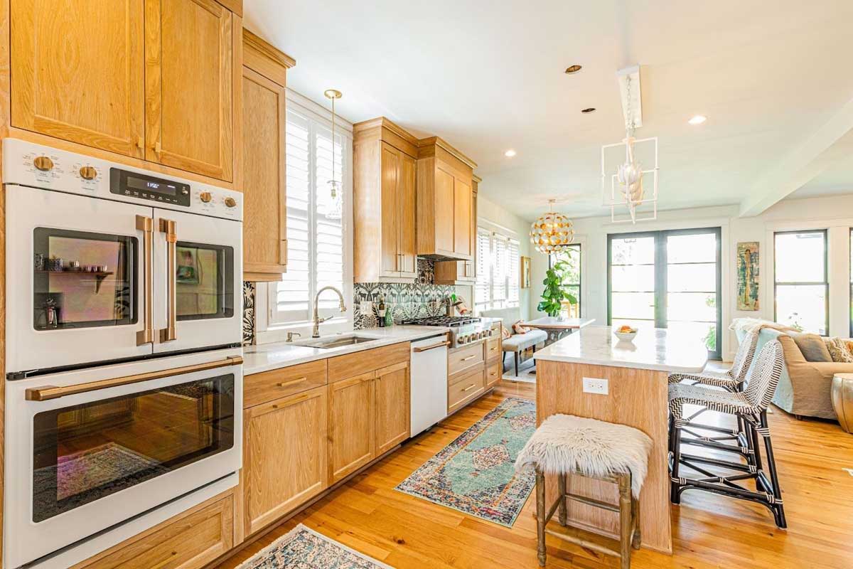 Kitchen remodel featuring double ovens; patterned backsplash; and fun and funky light fixtures