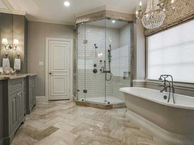 BK Martin bathroom remodel featuring a stand-alone tub, crystal chandelier, large shower, and double vanity