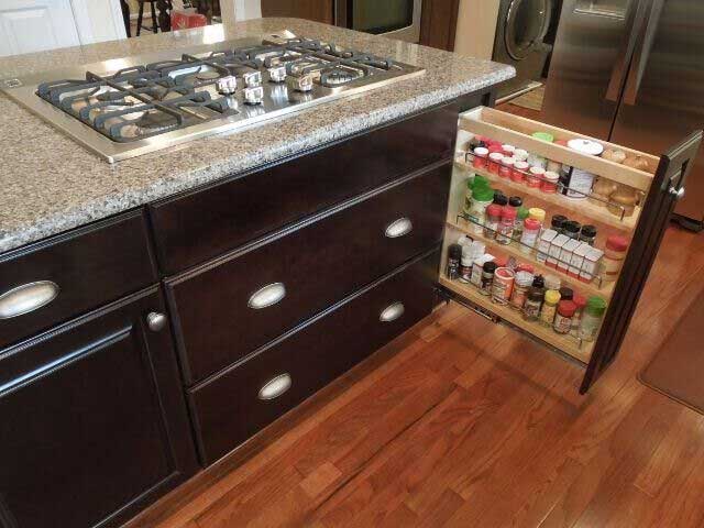 Gas stovetop in a kitchen island with a pull out spice drawer for easy access to spices and cooking oils