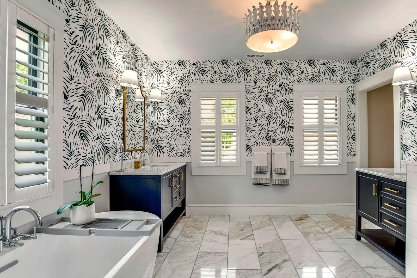 Remodeled bathroom featuring wall sconces, overhead chandelier and plenty of windows for natural light