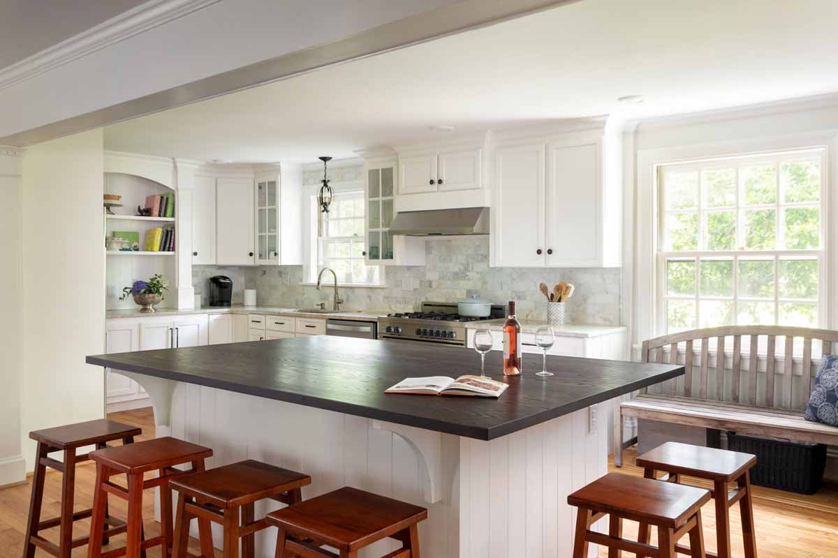 Classic white kitchen, huge island with seating for 6, and a built in bookshelf for cookbooks