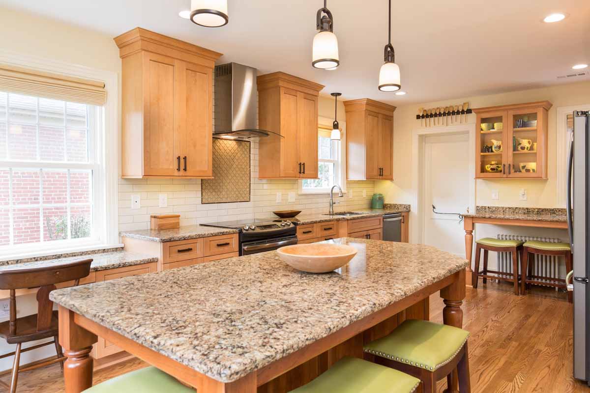 Natural wood cabinets and 3 pendant lights hanging over a center island