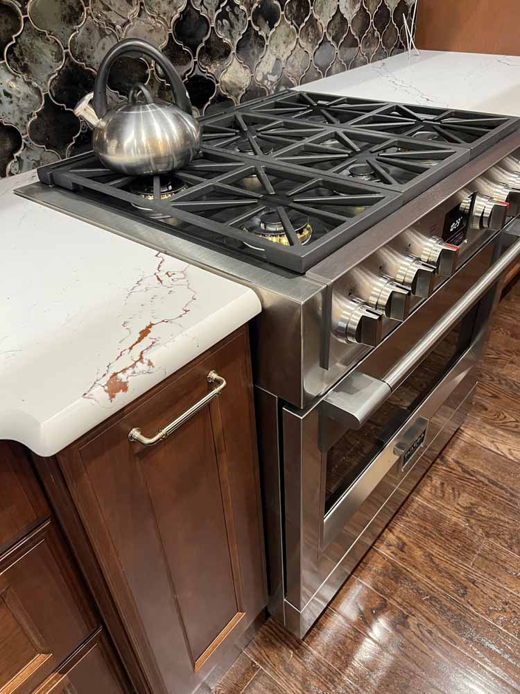 Cambria Inverness Bronze Quartz countertops are a light design with creams, whites, and lightning bolt streaks of bronze throughout