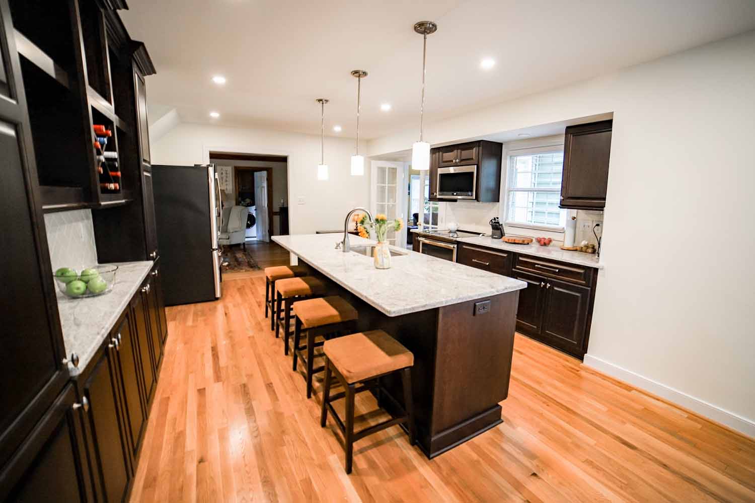 BK Martin kitchen with 2 walls of cabinetry and appliances and an island in the middle with the sink and seating