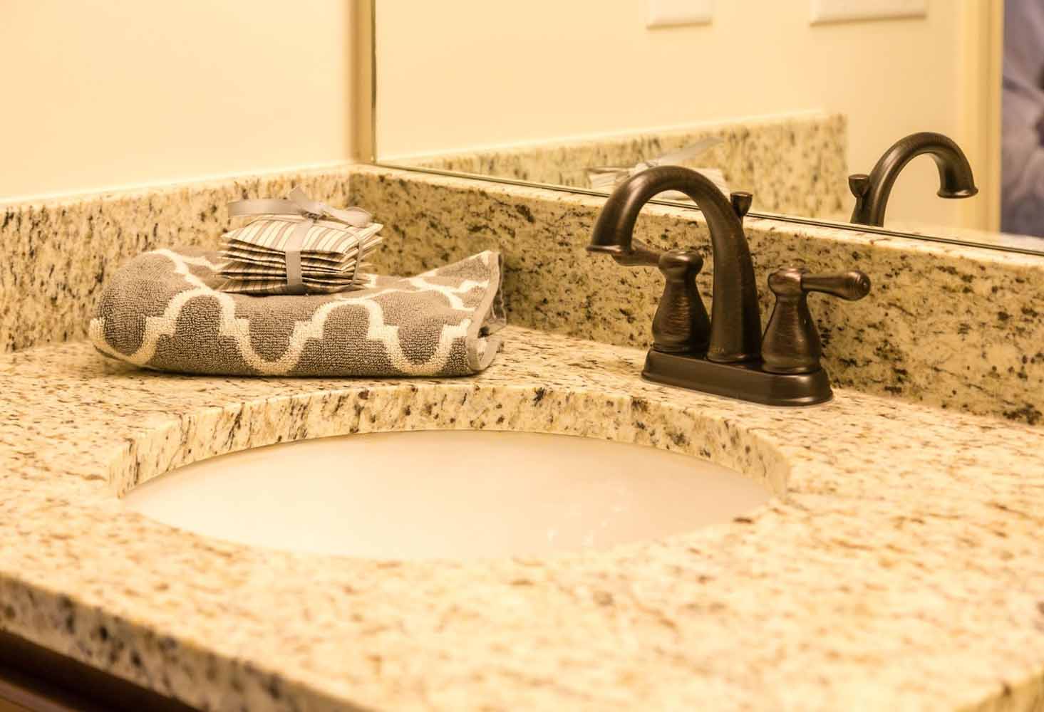 Bathroom sink with Granite Vanity and Bronze Fixtures