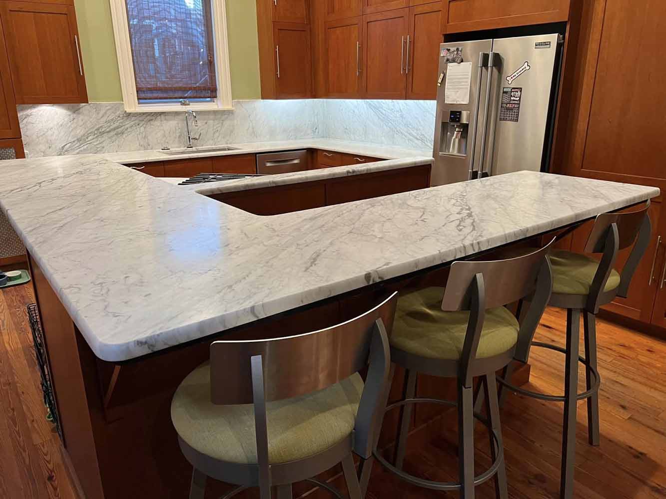 Continue the same material used for your countertops up the wall for your backsplash to create a cohesive look, like this BK Martin kitchen remodel.