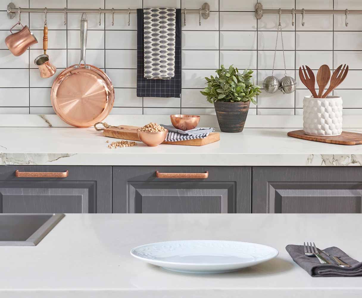 Decorative bars with hooks mounted to the backsplash provides hanging storage for pans, utensils, hand towels, and other frequently used items, freeing up counter space.