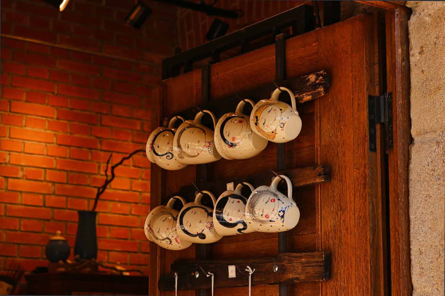 Functional and artstic storage shown by hanging beautiful mugs on a rack attached to a door
