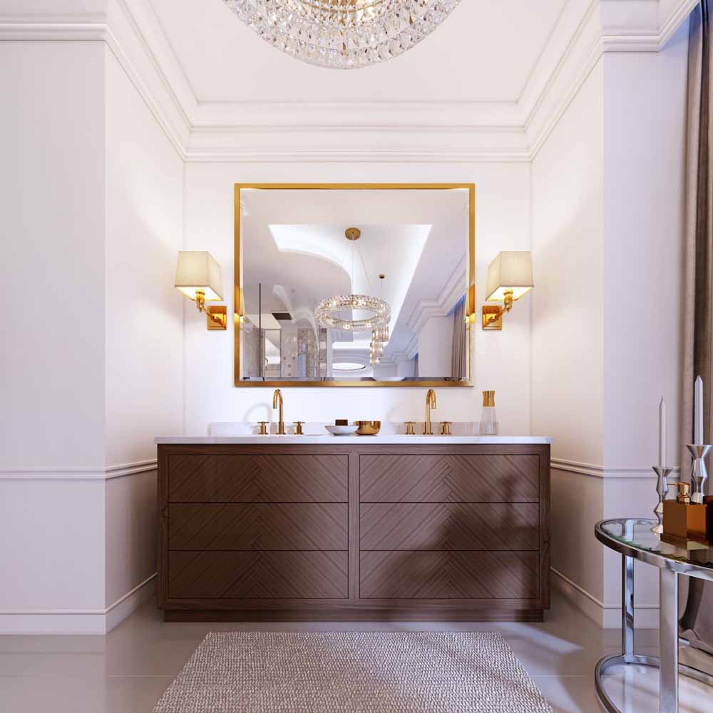 Modern wooden vanity with a mirror in a gold frame and sconces on the wall, a low table with decor and a rug with a chandelier