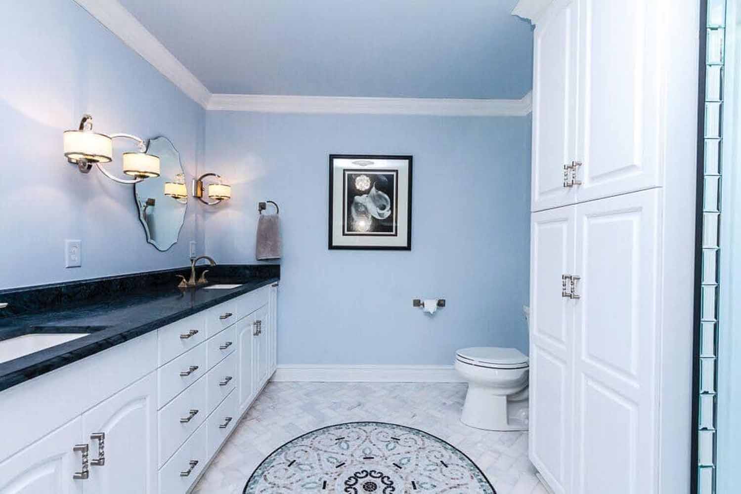 White vanity with 2 sinks and a black countertop