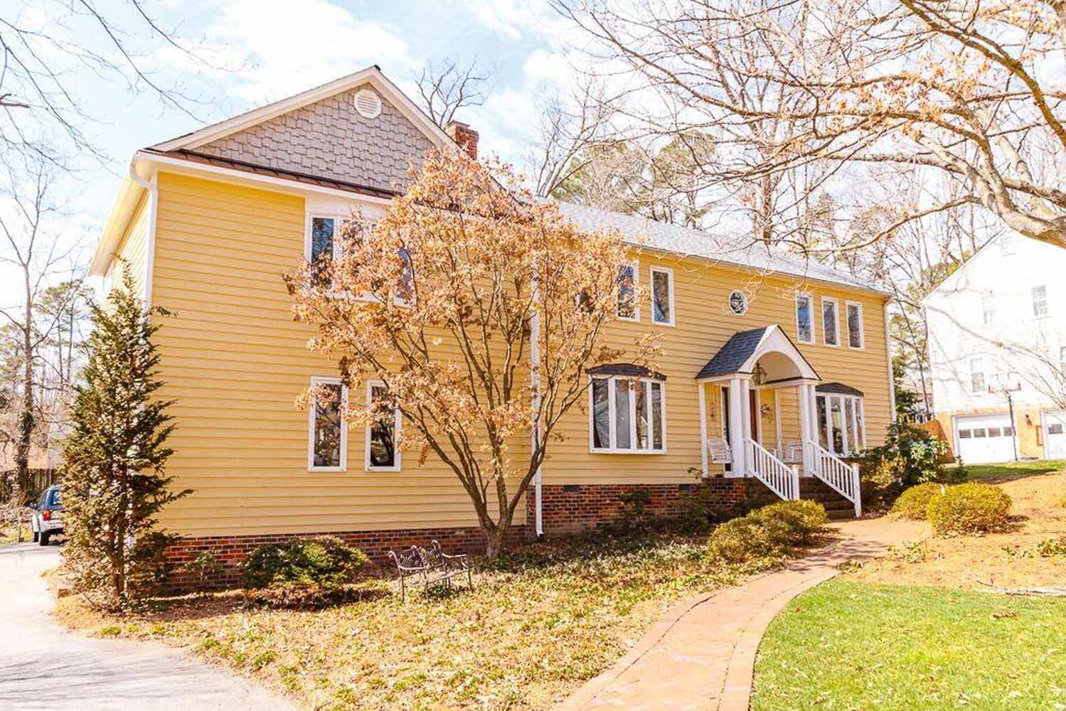 BK Martin second-story addition, over the garage, on this yellow Richmond, VA home